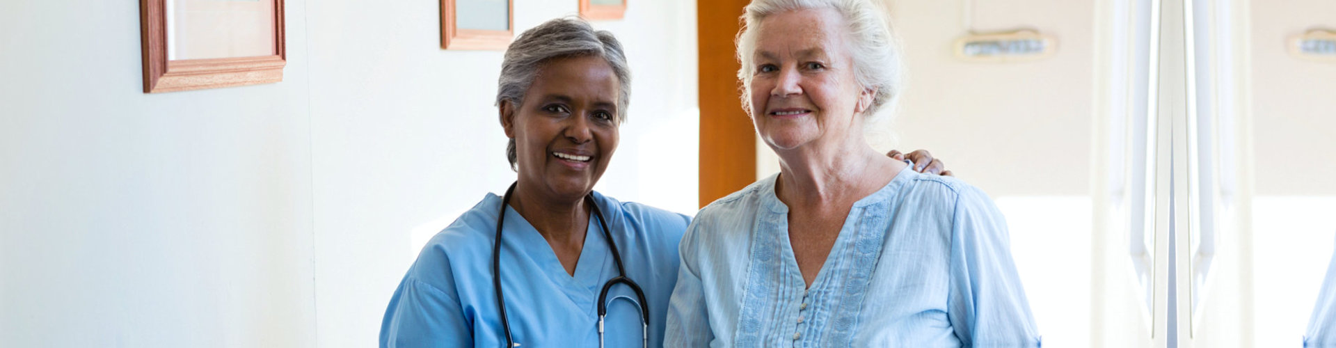 a nurse and a senior woman smiling